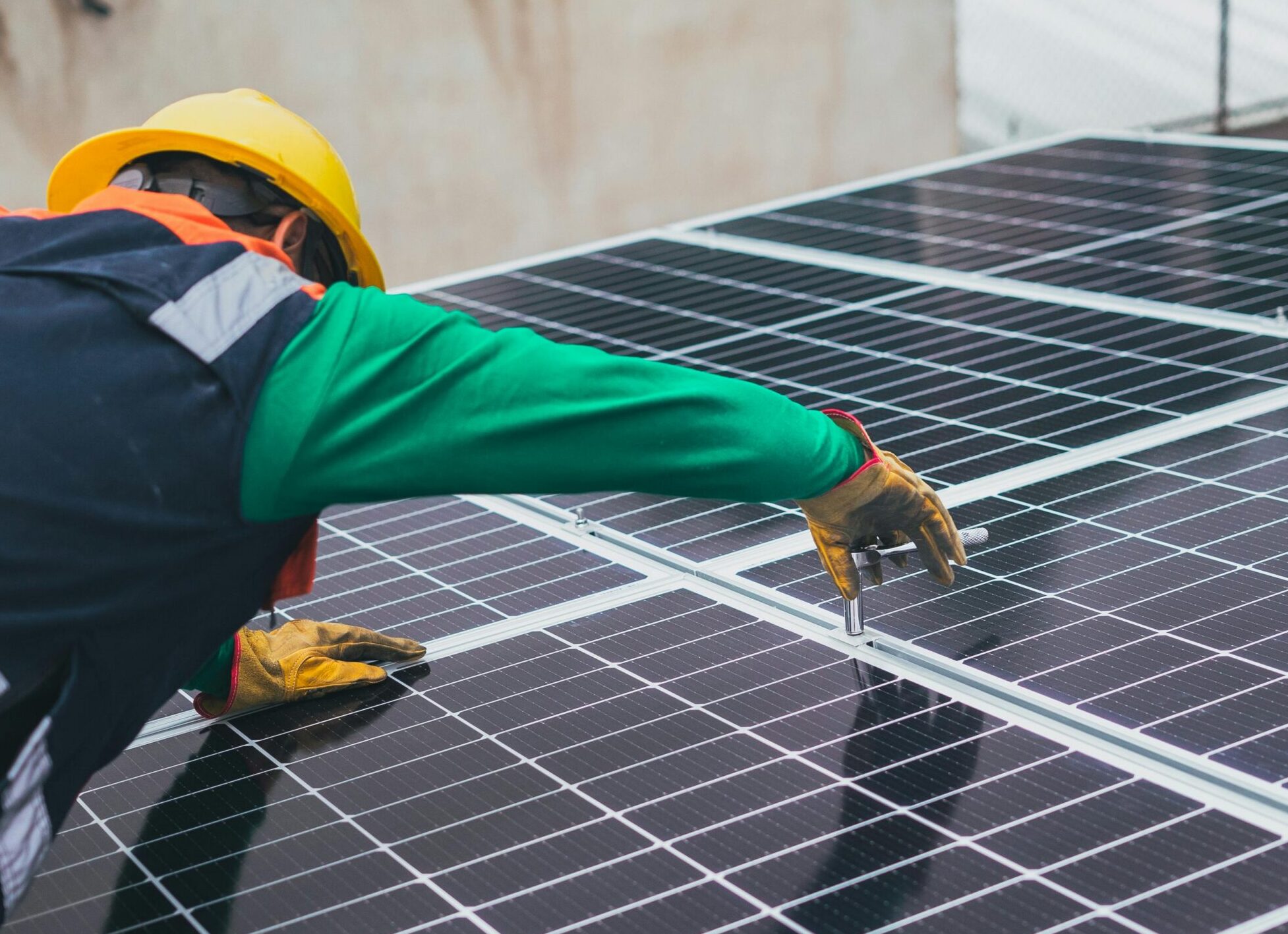 Technician installing solar panels on a rooftop for sustainable energy solutions.